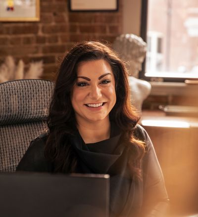 Lisa Arnold sitting at her desk, in front of a laptop